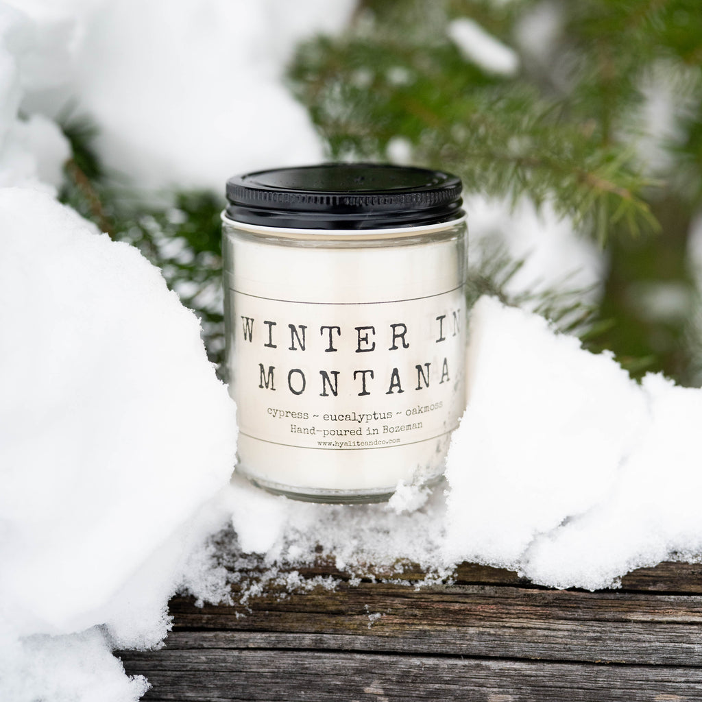 Candle labeled 'Winter in Montana' in a snowy setting