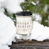 Candle labeled 'Winter in Montana' in a snowy setting