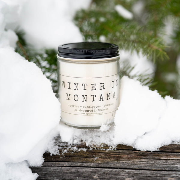 Candle labeled 'Winter in Montana' in a snowy setting