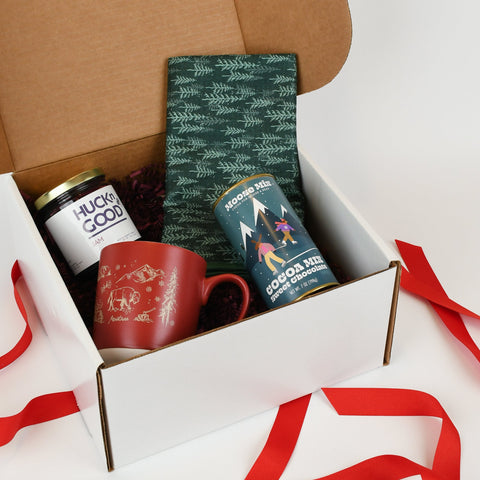 Gift box with tea towel, mug, hot cocoa and huckleberry jam