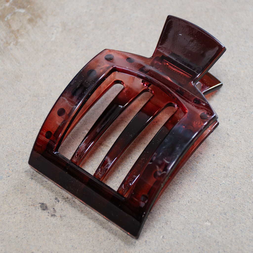 wine colored hair clip on a gray surface